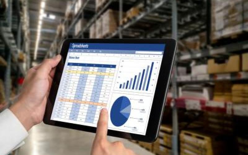 Hands pointing to a computer tablet showing charts