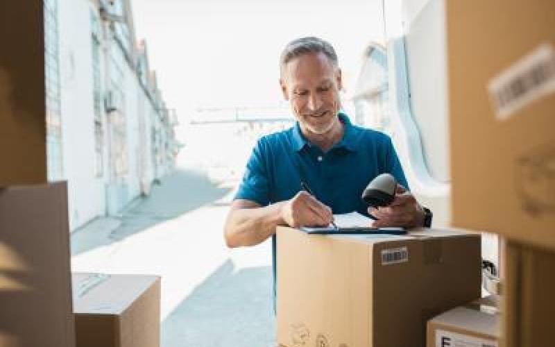 A warehouse worker scanning a barcode on a package label.