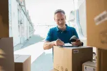 A warehouse worker scanning a barcode on a package label.