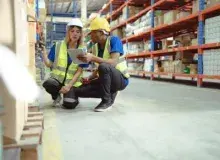 Two employees revising warehouse inventory